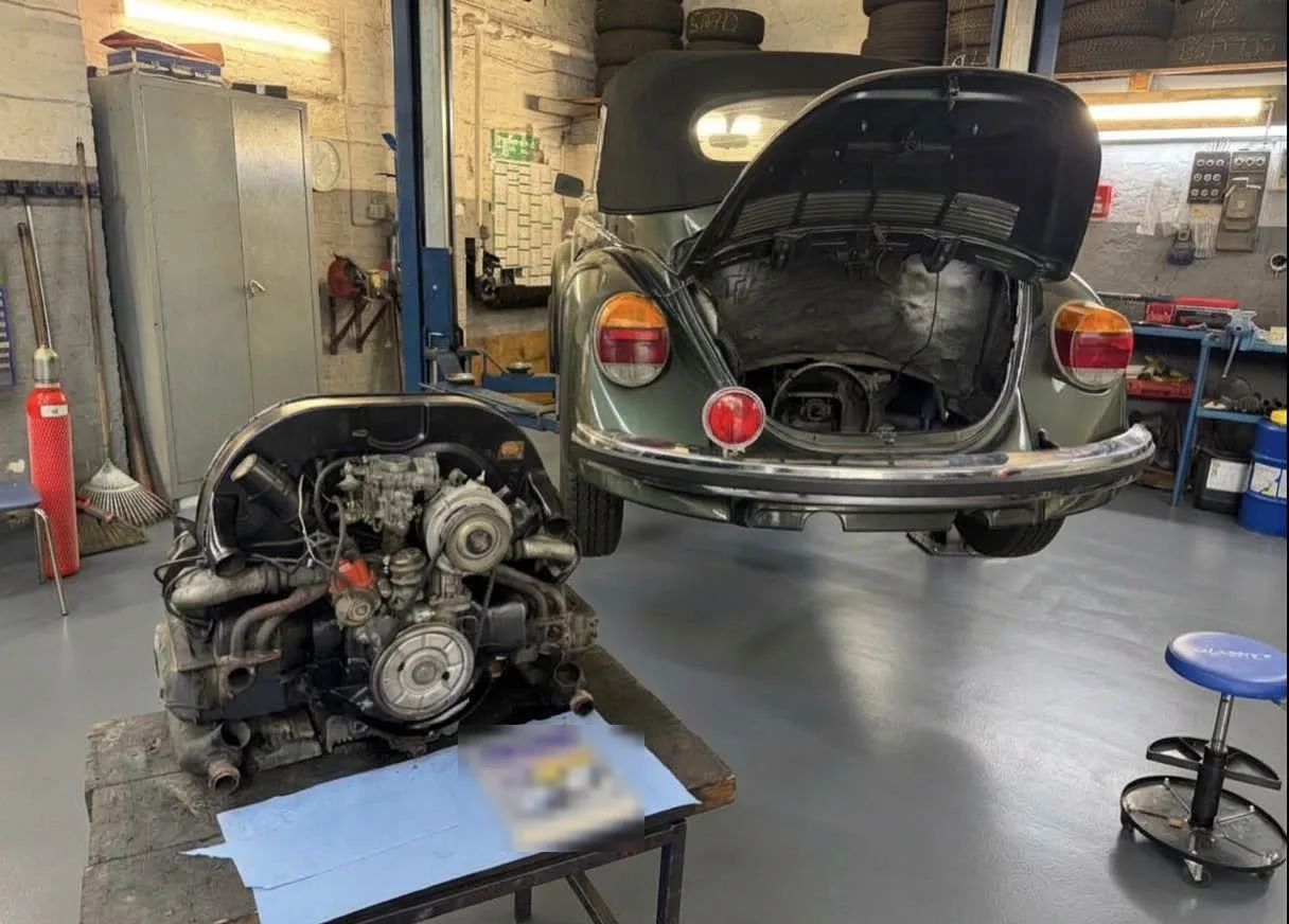VW Käfer Werkstatt in Hamburg-Wandsbek: Käfer mit offener Heckklappe und ausgebautem Boxermotor in der Werkstatt von A&H Schwarz Autotechnik
